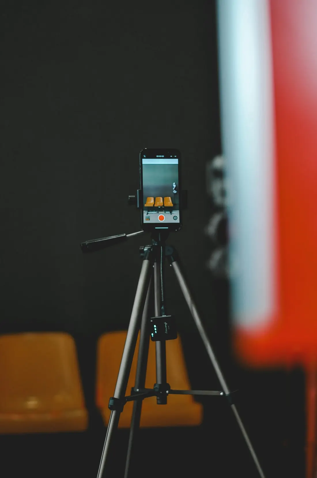 An iPhone on a tripod recording in a dim venue